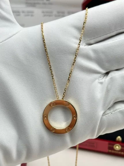 Cartier Love Pendant B7014200 in 18k yellow gold, close-up on a white glove