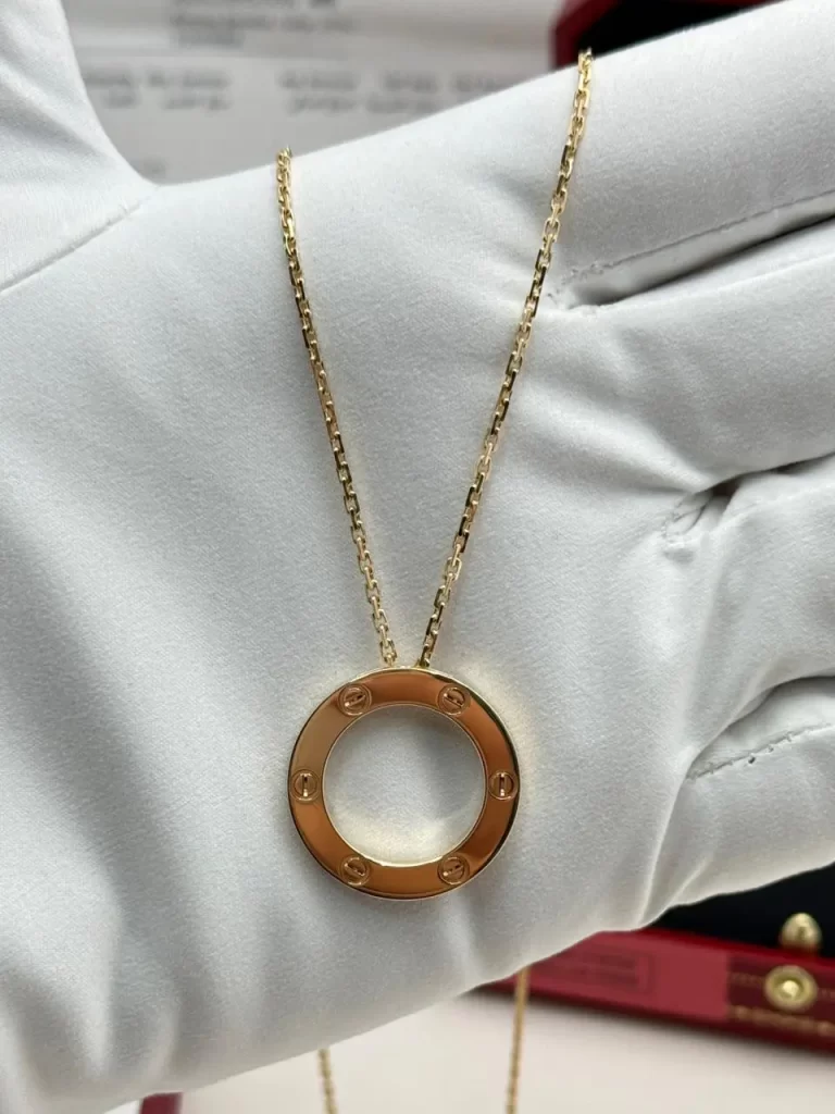 Cartier Love Pendant B7014200 in 18k yellow gold, close-up on a white glove
