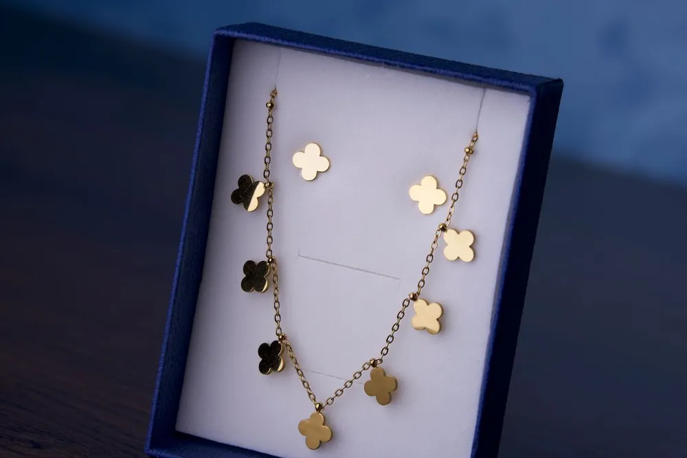 Gold clover necklace in a gift box, a lookalike to check when you spot a fake Van Cleef Alhambra necklace
