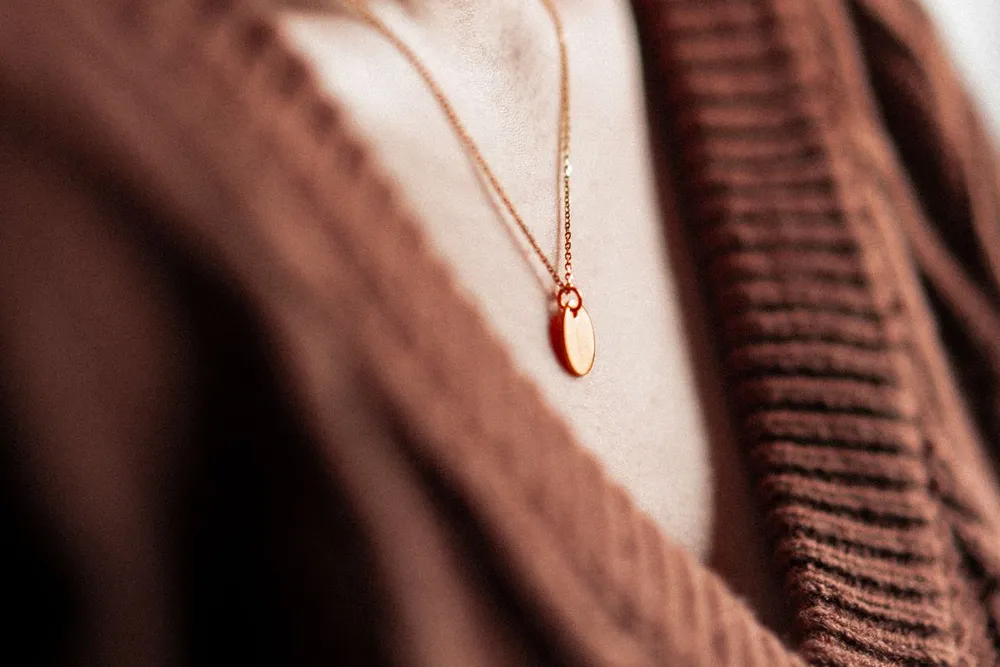 Gold pendant resting at princess length on the collarbone, a necklace length guide example