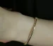 Ecrou de Cartier guide: a slim gold bangle bracelet with small stones worn on a wrist