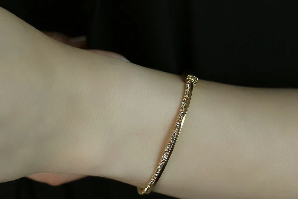 Ecrou de Cartier guide: a slim gold bangle bracelet with small stones worn on a wrist