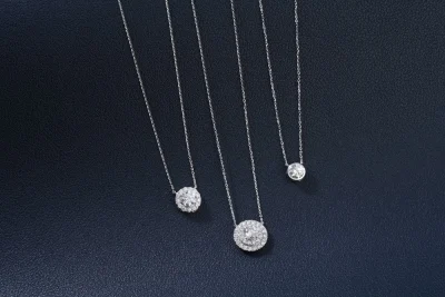 Three designer pieces of a luxury diamond necklace in Dubai on a blue background
