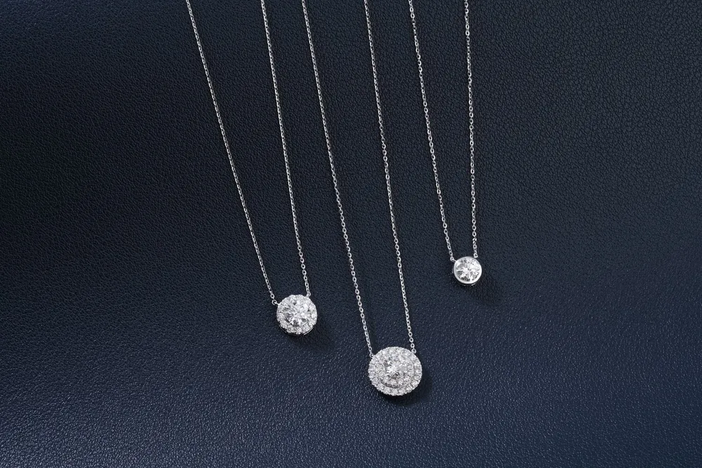 Three designer pieces of a luxury diamond necklace in Dubai on a blue background