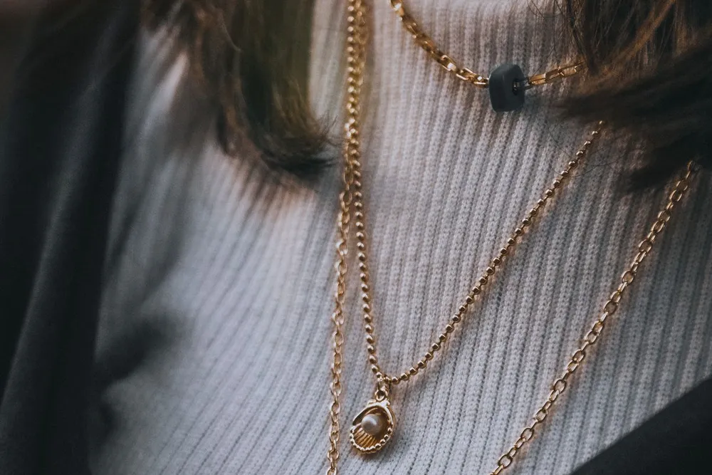 Layered gold chains on the neck, a necklace length guide example