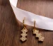 Gold flower earrings on a wooden table, a look close to Van Cleef Frivole earrings