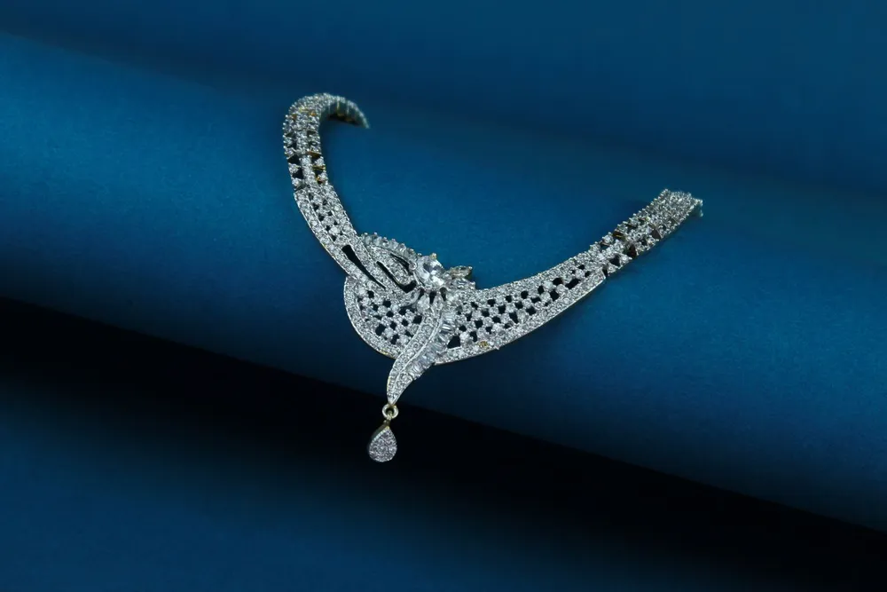 Close-up of a diamond necklace certificate check detail on a deep blue background