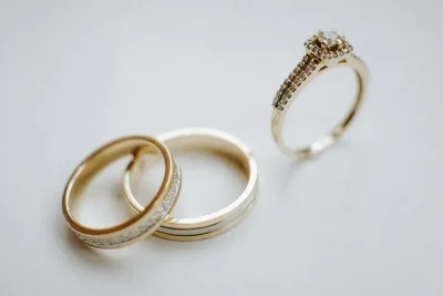 Cartier Love ring vs wedding band: two gold wedding bands and a diamond engagement ring side by side