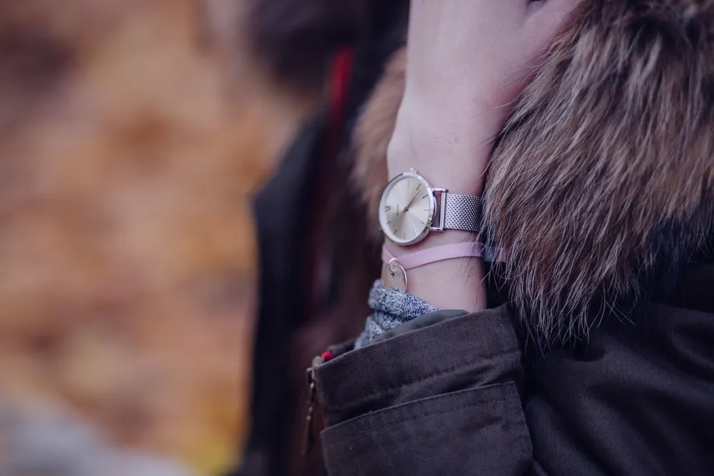 Cartier Santos medium vs large: a silver wristwatch worn on the wrist outdoors