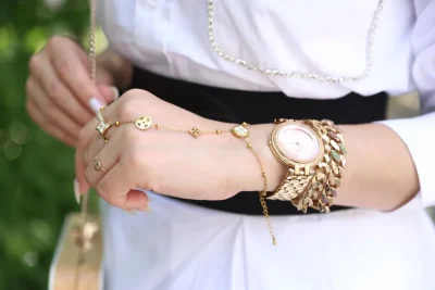 Cartier Love bracelet worth it: a gold bracelet and a gold watch on a wrist