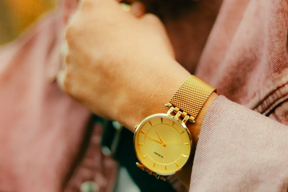 Bvlgari Serpenti watch vs Cartier Panthere: a gold mesh-strap ladies watch with a round dial on the wrist