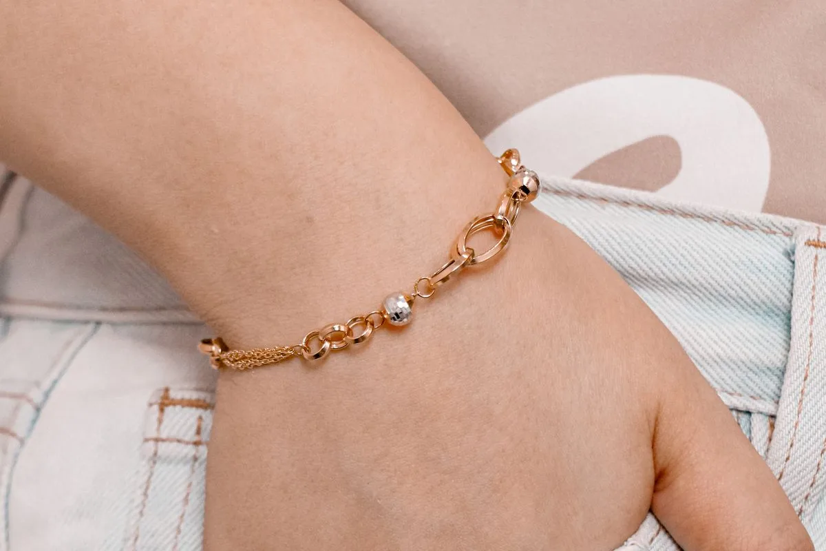 Van Cleef Alhambra vs Cartier Love: a flexible gold chain bracelet resting on the wrist