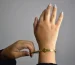 Van Cleef Alhambra vs Cartier Love bracelet comparison: hands adjusting a gold bracelet