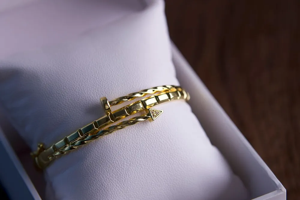 Is the Cartier Love bracelet worth it? A gold bracelet resting on a cushion in an open gift box