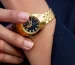 Cartier Panthere watch strap adjustment: hand adjusting a gold link bracelet wristwatch