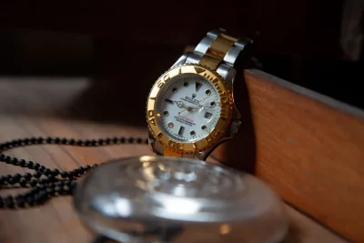 Luxury watch valuation in Dubai: a two-tone gold and steel watch with a white dial on a wooden table