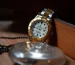 Luxury watch valuation in Dubai: a two-tone gold and steel watch with a white dial on a wooden table