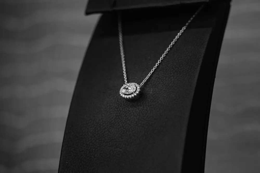 Diamond pendant on a black display stand, in the style of a Messika Move Uno necklace in Dubai
