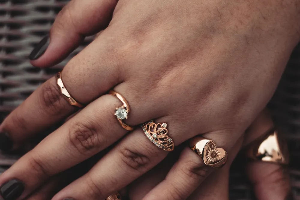 Ecrou de Cartier guide: a hand wearing several slim gold rings to show how ring sizes sit on the finger
