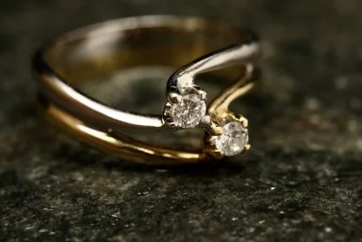 Van Cleef Alhambra ring style gold band with two diamonds on dark stone