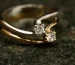 Van Cleef Alhambra ring style gold band with two diamonds on dark stone
